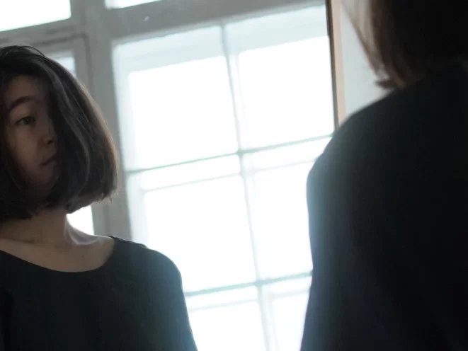 Woman looking in the mirror.